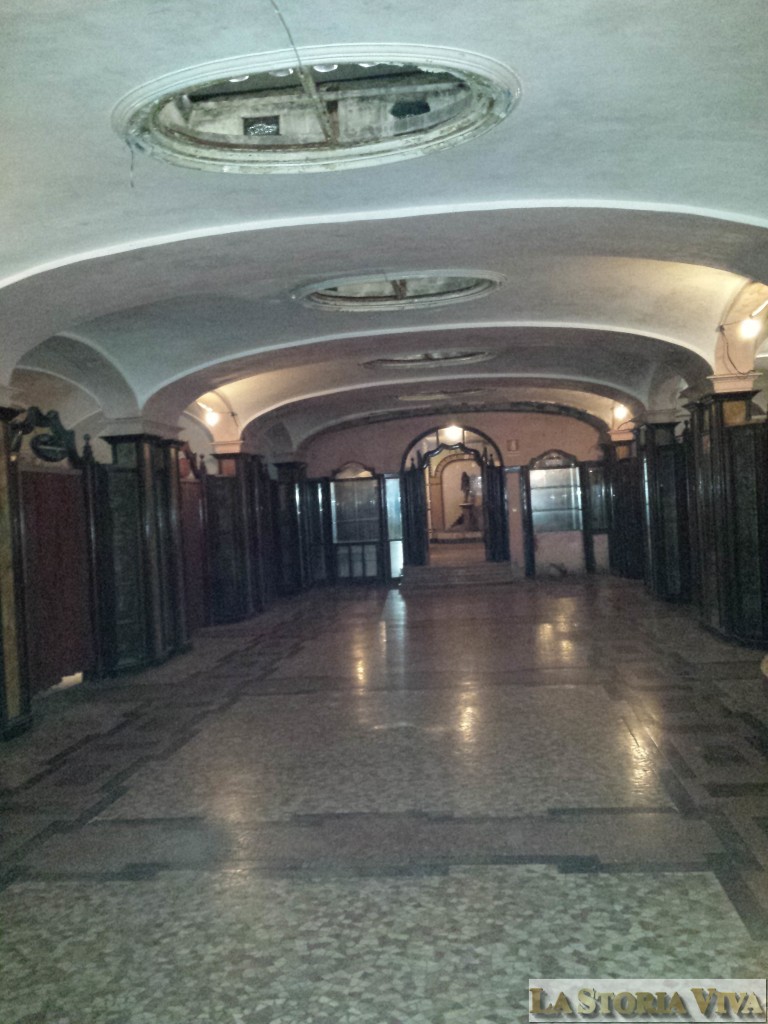 Il salone di ingresso come si presenta oggi, dopo l'intervento di pulizia e rioridino del FAI. Sui due lati si aprono le porte in legno dei singoli "negozi". Non sono più visibili gli affreschi del soffitto e sono scomparsi i divanetti che si collocavano al centro del salone.