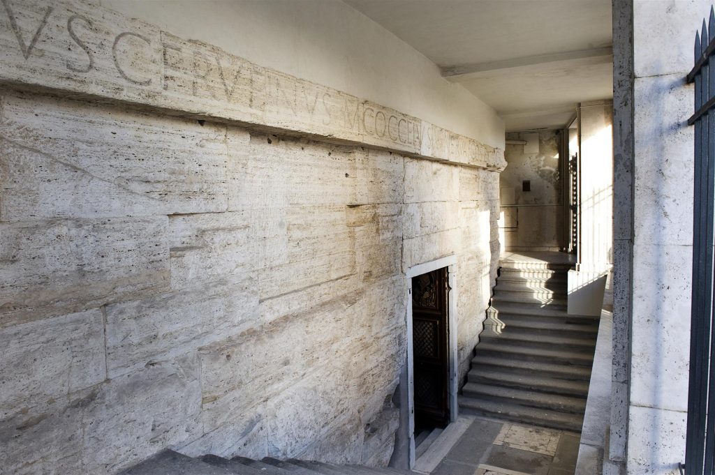 Facciata in travertino con dedica senatoria ai consoli C. VIBIUS RUFINUS e M. COCCEIUS NERVA, che restaurarono il complesso sotto Tiberio (39-42 d.C.)