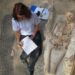 Un'archeologa registra i dati dopo la scoperta di un sarcofago in pietra (LP/CH)